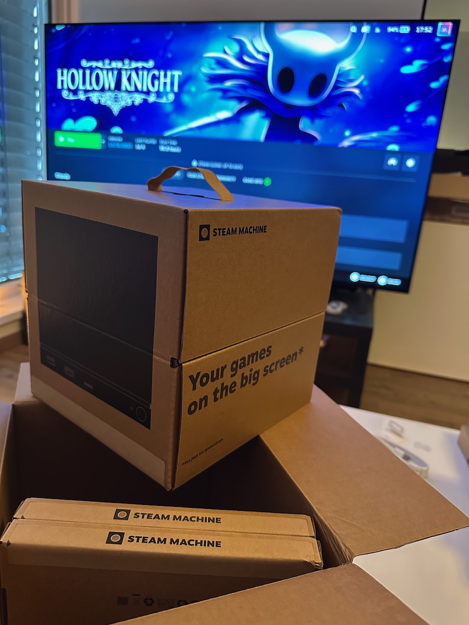 Unopened Steam Machine box in front of my TV displaying the Steam Deck